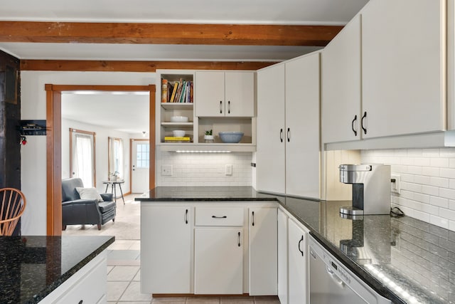 kitchen with stainless steel dishwasher, white cabinets, dark stone countertops, light tile patterned floors, and backsplash