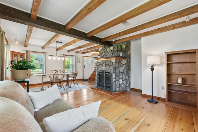 living room featuring a fireplace, beam ceiling, and light hardwood / wood-style flooring