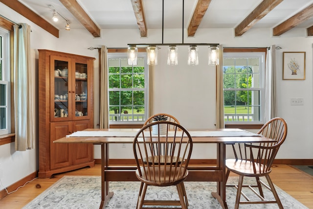 dining space with light wood-type flooring and beam ceiling