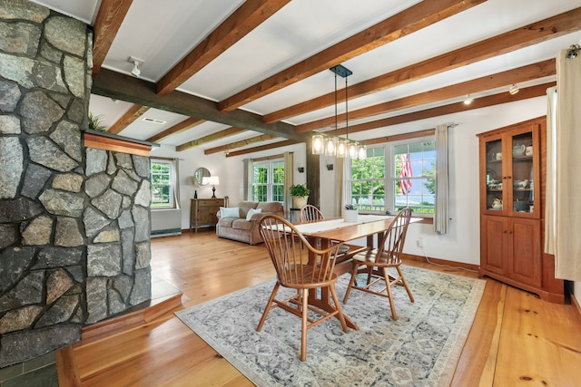 dining area featuring beam ceiling and light wood-type flooring