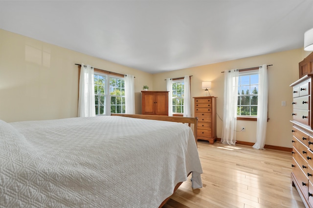 bedroom with light wood-type flooring and multiple windows