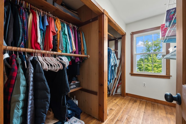 walk in closet with light hardwood / wood-style flooring