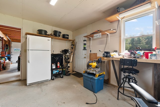 garage with white fridge and a workshop area