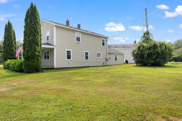 rear view of property featuring a yard