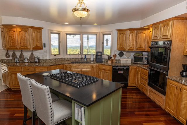 kitchen with dark wood-type flooring, black appliances, sink, and a healthy amount of sunlight