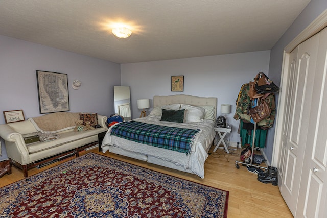 bedroom with a textured ceiling and light hardwood / wood-style floors