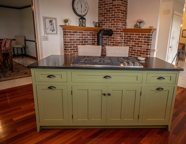 kitchen featuring dark wood-type flooring, green cabinets, and a wood stove