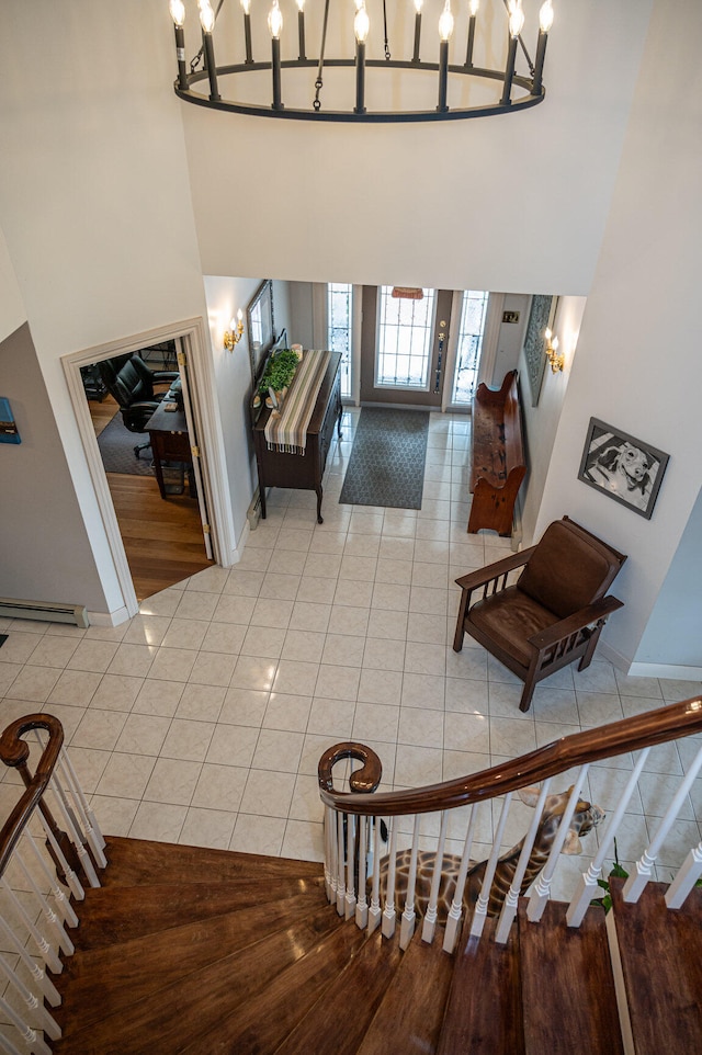 stairs with a notable chandelier, hardwood / wood-style floors, and a high ceiling