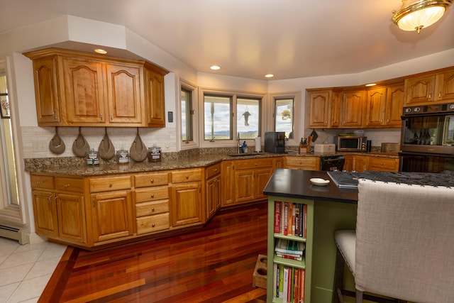 kitchen with sink, backsplash, dark hardwood / wood-style flooring, and black appliances