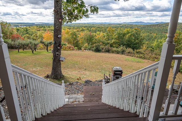 wooden deck featuring a yard and a mountain view