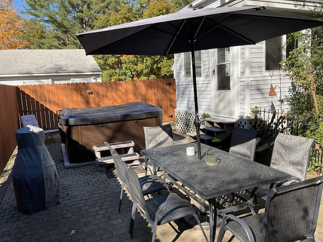 view of patio / terrace featuring a hot tub and a grill