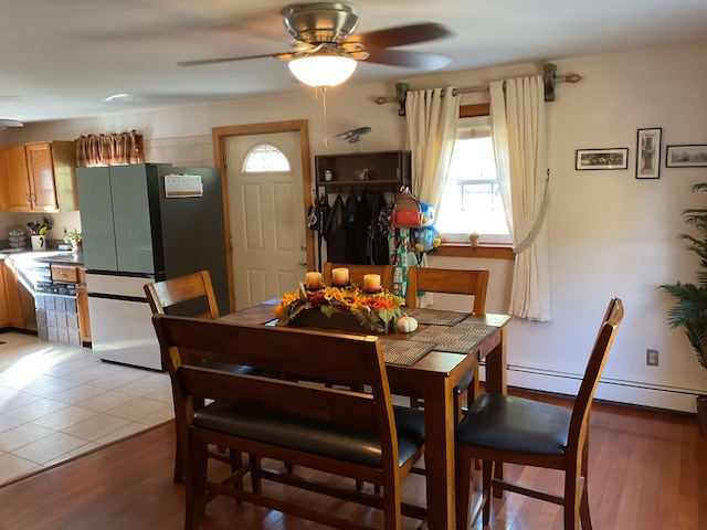 dining space featuring baseboard heating, hardwood / wood-style flooring, and ceiling fan