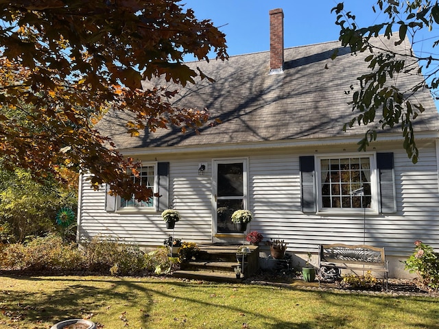 cape cod home featuring a front lawn