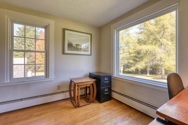 office area featuring light hardwood / wood-style flooring, a healthy amount of sunlight, and baseboard heating