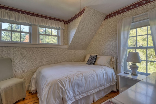 bedroom featuring multiple windows and light wood-type flooring