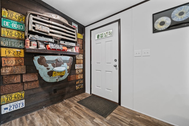 foyer entrance featuring wood-type flooring and crown molding