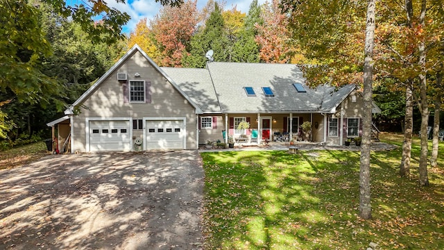 new england style home featuring covered porch, a front yard, and a garage