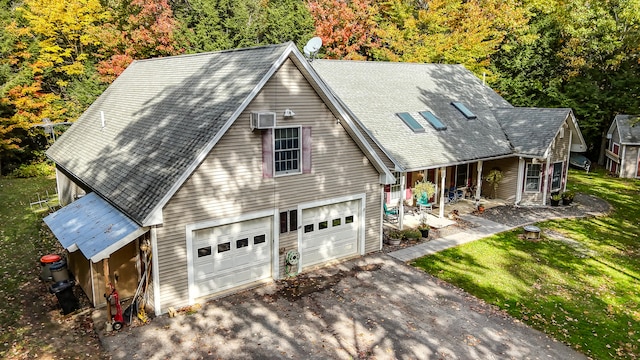 view of front facade with a front yard, an AC wall unit, and a garage