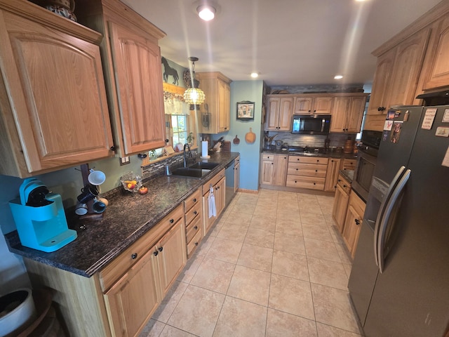 kitchen featuring light tile patterned floors, dark stone counters, black appliances, sink, and decorative light fixtures