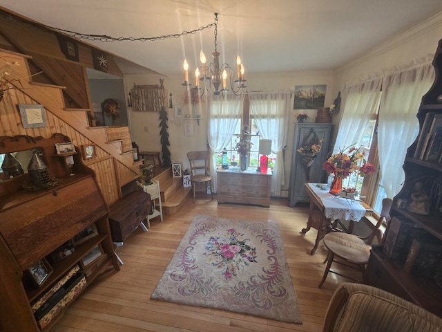 dining space with light hardwood / wood-style flooring, ornamental molding, and a chandelier