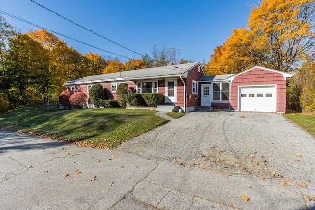 ranch-style house featuring a garage and a front lawn