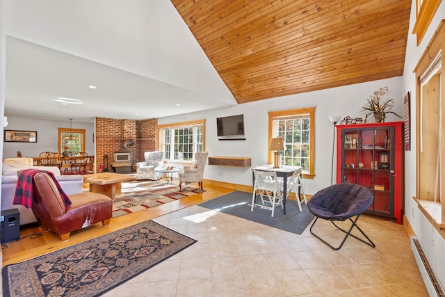 tiled living room featuring a healthy amount of sunlight, a wood stove, a baseboard radiator, and lofted ceiling