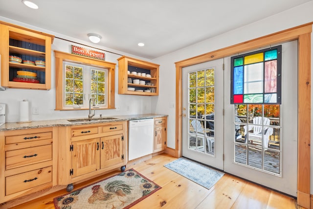 bar featuring sink, dishwasher, light hardwood / wood-style flooring, and light stone counters