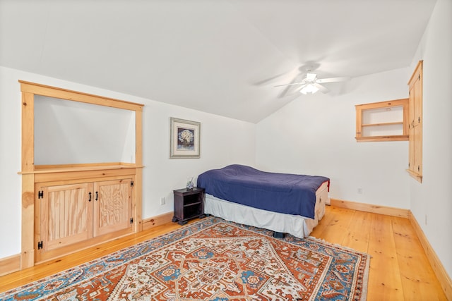 bedroom with hardwood / wood-style floors, vaulted ceiling, and ceiling fan