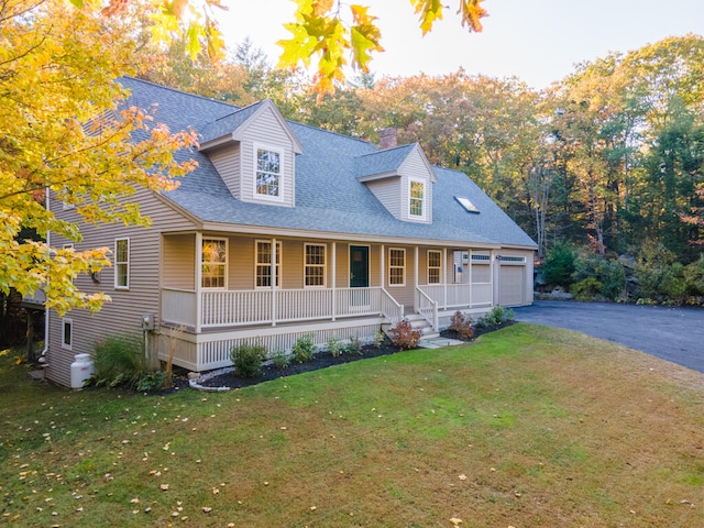 cape cod-style house featuring covered porch, a garage, and a front lawn