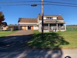 view of front of property featuring covered porch and a front lawn