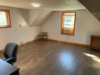 bonus room featuring dark wood-type flooring, lofted ceiling, a wealth of natural light, and cooling unit