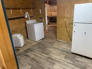 laundry area featuring heating unit, wood-type flooring, and washing machine and clothes dryer