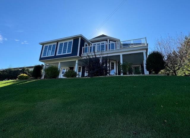 view of front facade with a front lawn and a balcony