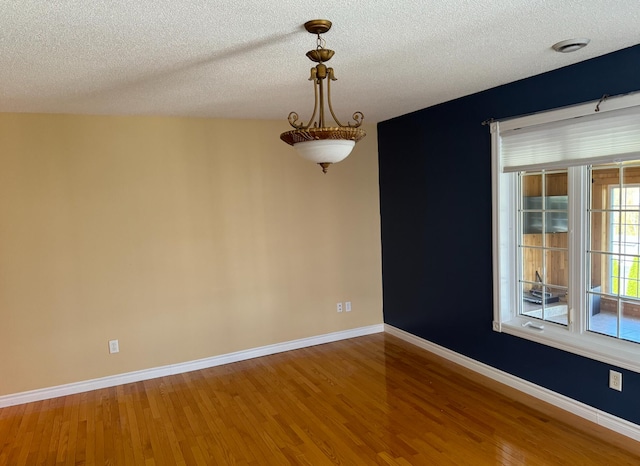 unfurnished room featuring a textured ceiling and hardwood / wood-style flooring