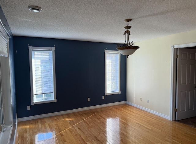 empty room featuring wood-type flooring and a textured ceiling