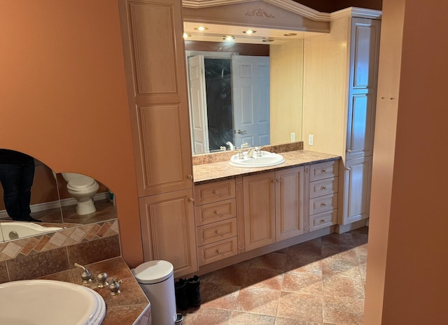 bathroom featuring vanity, toilet, a tub to relax in, and tile patterned flooring