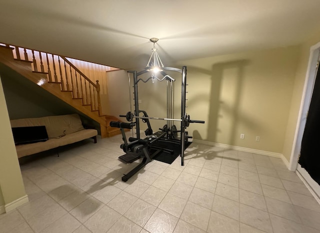 exercise area featuring light tile patterned flooring and an inviting chandelier