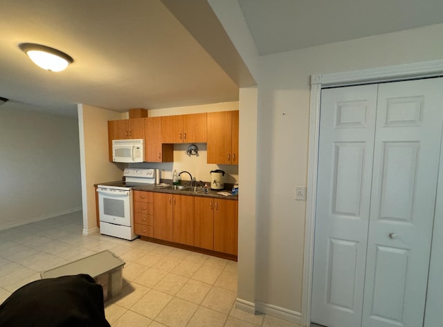 kitchen featuring white appliances, light tile patterned flooring, and sink