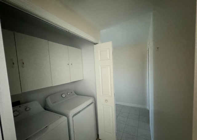 laundry area featuring light tile patterned floors, cabinets, and separate washer and dryer