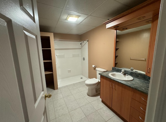 bathroom with tile patterned floors, toilet, a shower, vanity, and a paneled ceiling