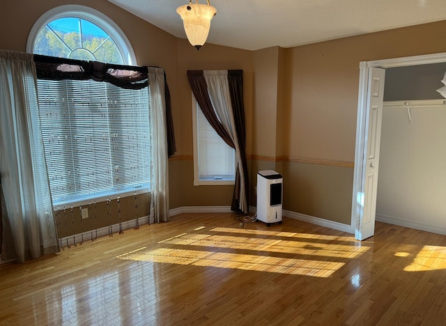 unfurnished bedroom featuring a closet, light wood-type flooring, and vaulted ceiling