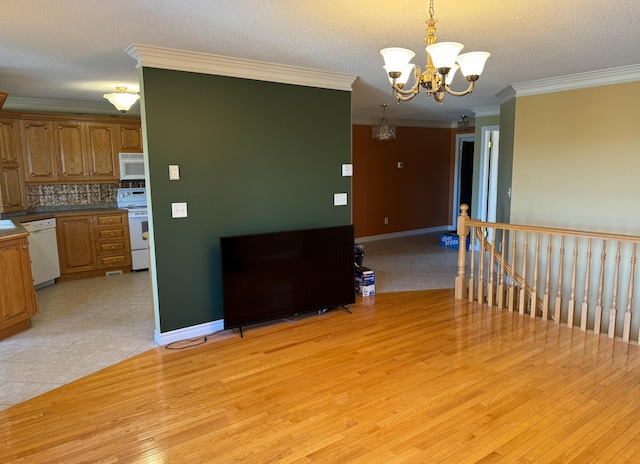 kitchen featuring white appliances, crown molding, light hardwood / wood-style flooring, and pendant lighting