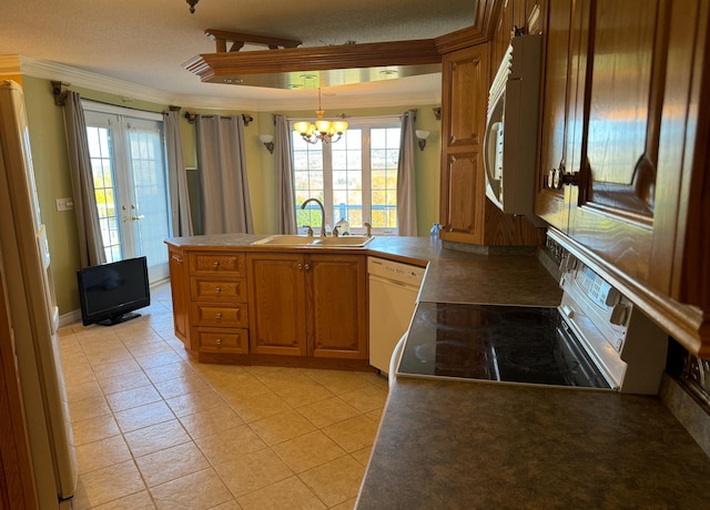 kitchen with white appliances, a notable chandelier, a textured ceiling, and sink