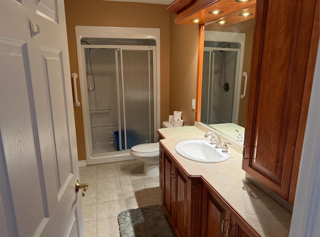 bathroom with vanity, a shower with shower door, toilet, and tile patterned floors