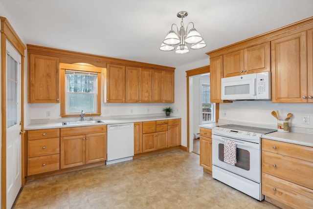 kitchen with hanging light fixtures, sink, white appliances, and a notable chandelier