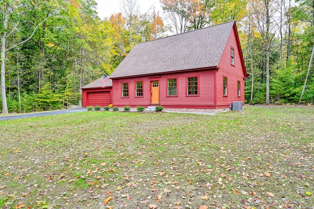 view of front of property with a front yard, cooling unit, and a garage