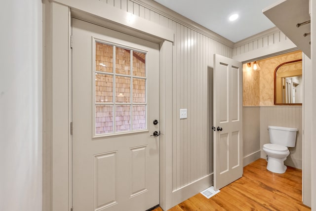 entryway with crown molding and wood-type flooring