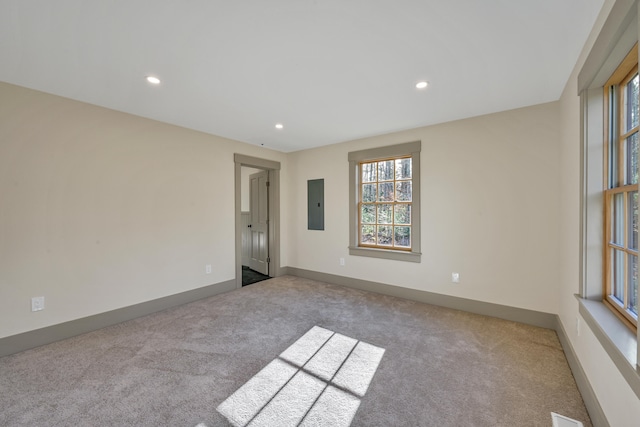 spare room with electric panel and light colored carpet