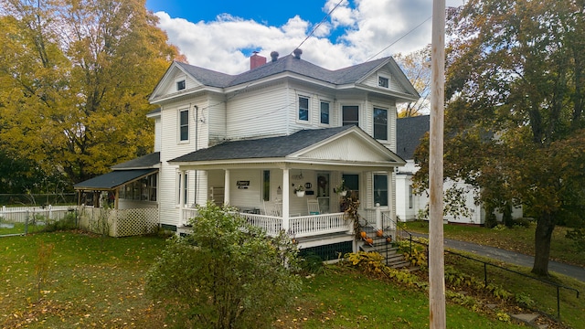 view of front of house with covered porch and a front lawn