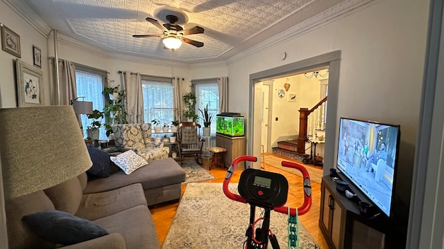 living room featuring crown molding, light wood-type flooring, and ceiling fan